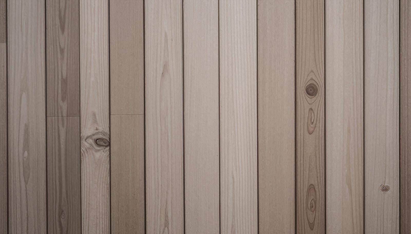 Floorboards with multiple boards laid vertically. Wood grain and knot holes are evenly distributed with thin gaps between boards.