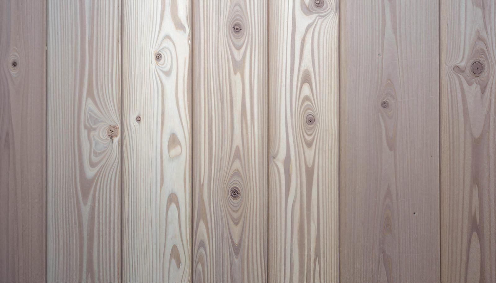 縦に並ぶベージュ色の木製板にテクスチャーと木目が見える背景