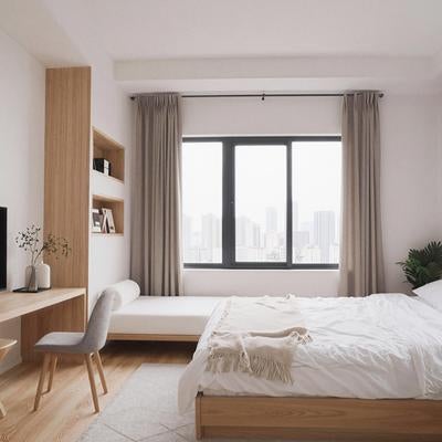 木製家具と大きな窓が特徴のワンルームベッドルームの写真