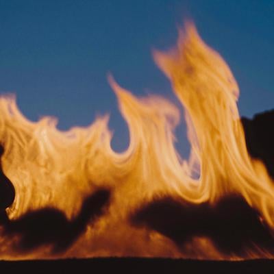 夜間に燃え上がるキャンプファイヤーの火炎風景の写真