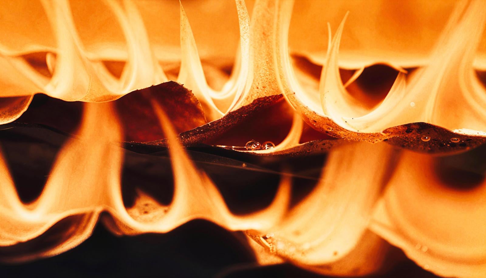 Intense flames glowing in orange and yellow blazing upward in wave-like patterns