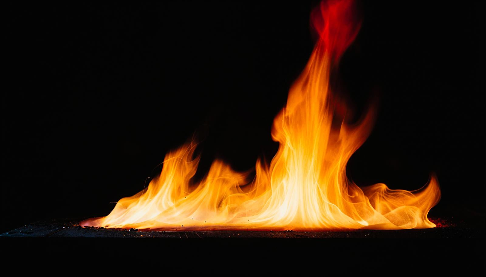 Fire pillar rising against a black background, flames changing from white to red
