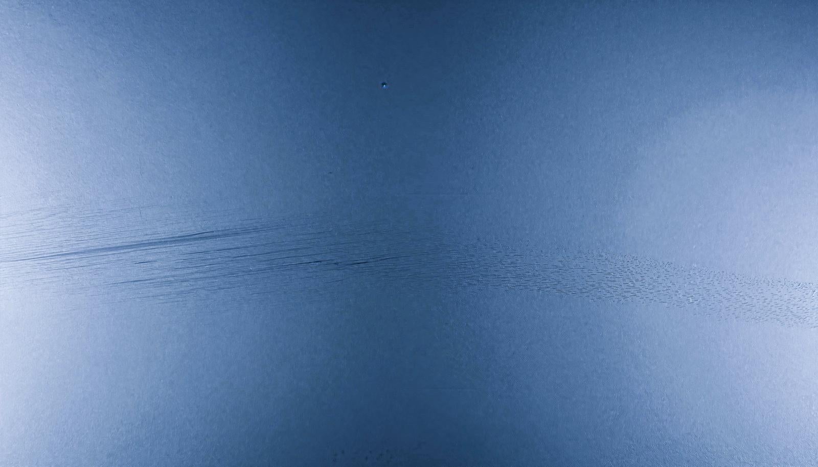 横方向のひっかき傷が入った青い表面のテクスチャーをクローズアップで捉えたAI画像