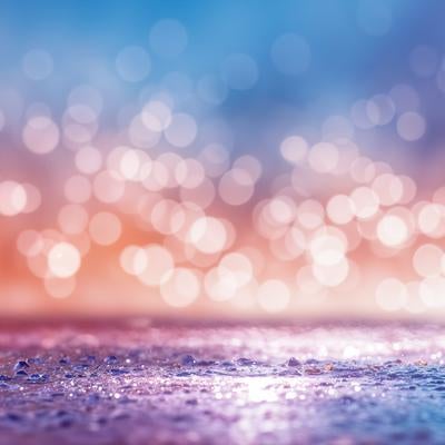 オレンジからブルーへ変化する夕空と水面の玉ボケの写真