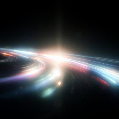 暗闇の中を弧を描くように流れる鮮やかな光の筋の写真