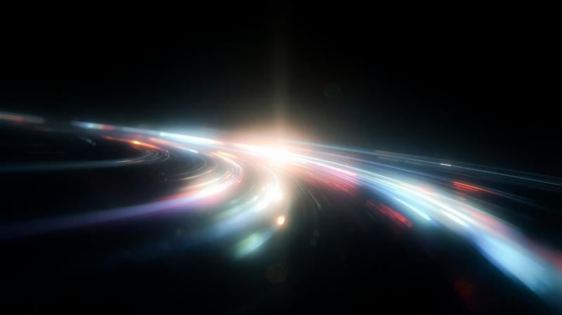 暗闇の中を弧を描くように流れる鮮やかな光の筋の写真