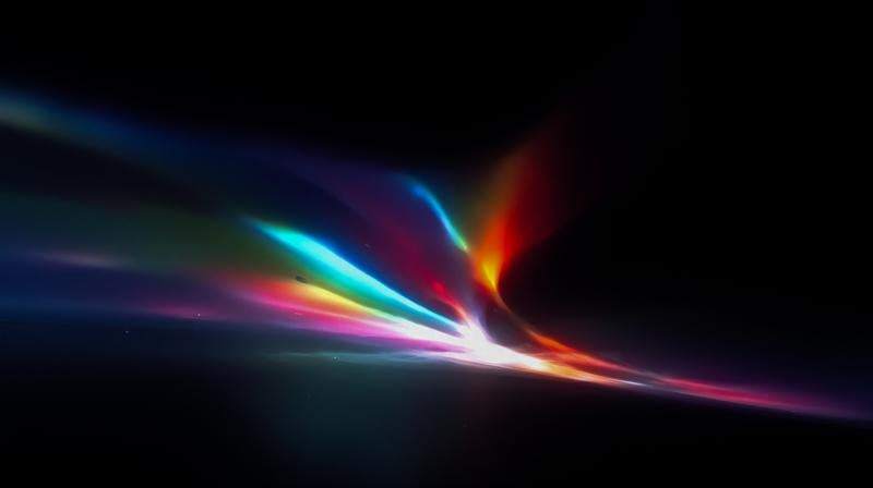 暗闇に広がる虹色の光線が放射状に輝く幻想的な光景の写真