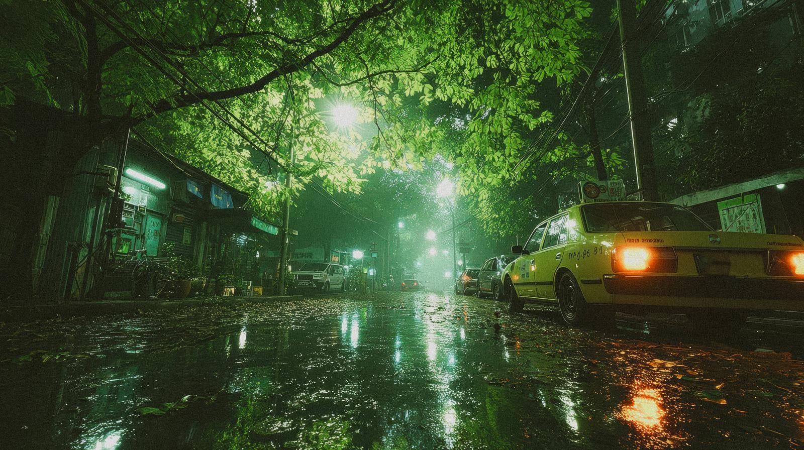 「雨上がりの静かな夜道に灯るタクシーのテールランプ」の写真