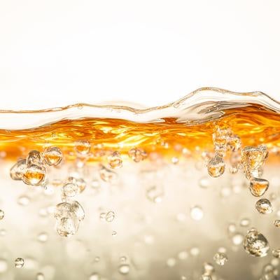 黄金色に染まる水面と水中に沸く気泡の写真