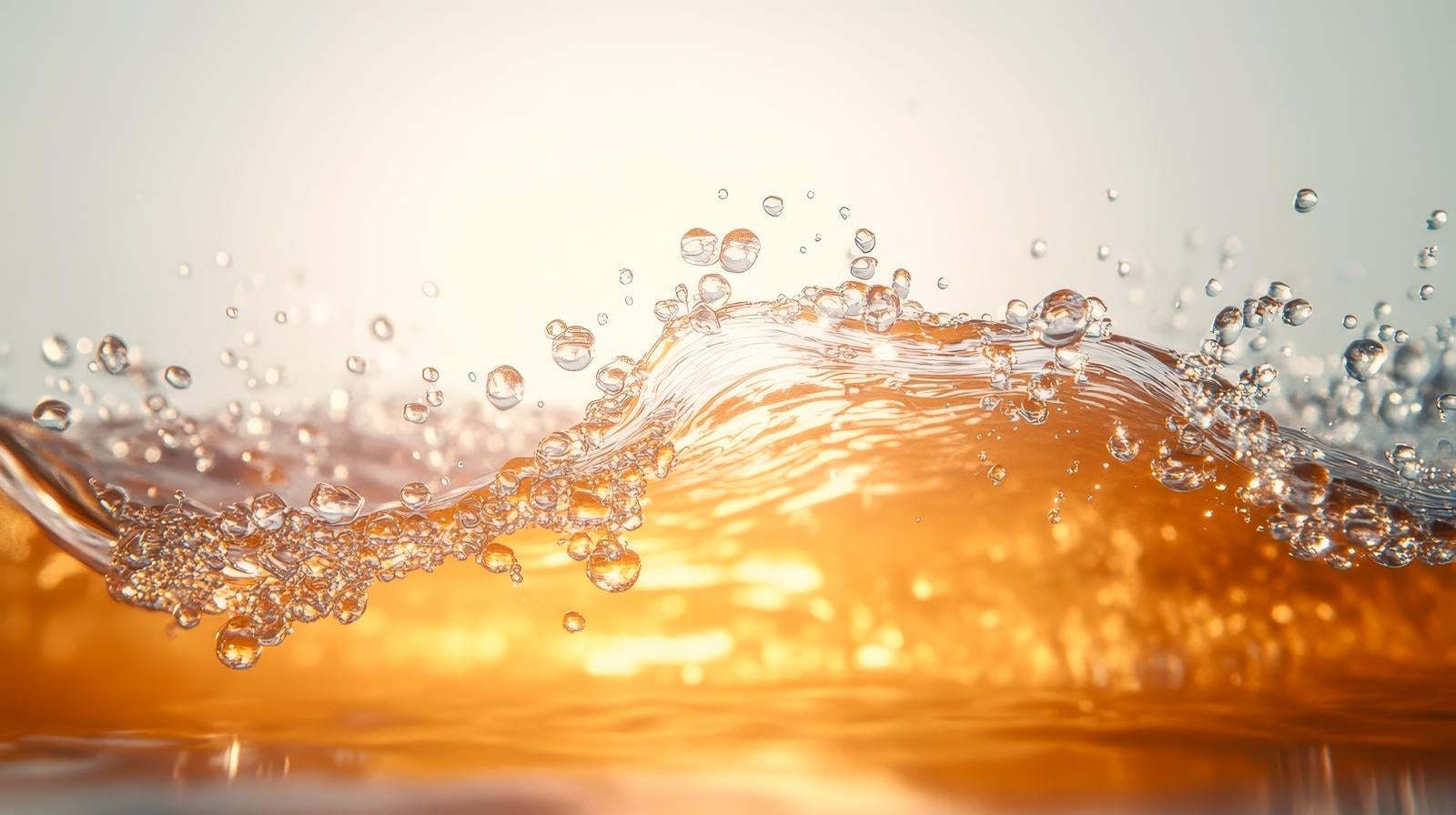 「琥珀色の透明感ある水しぶき」の写真