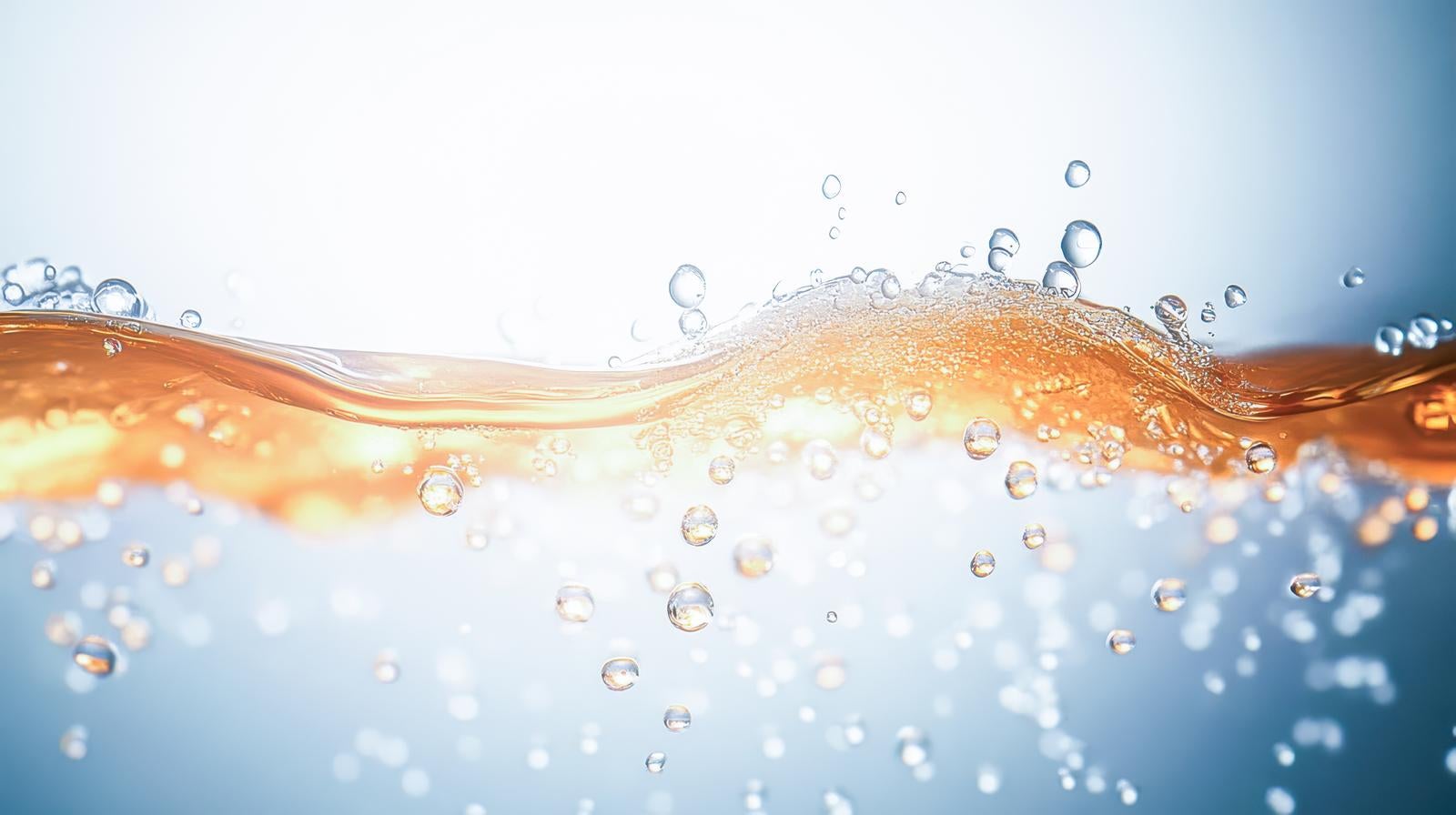 「光を受けて輝く透明な気泡と波打つ液体」の写真