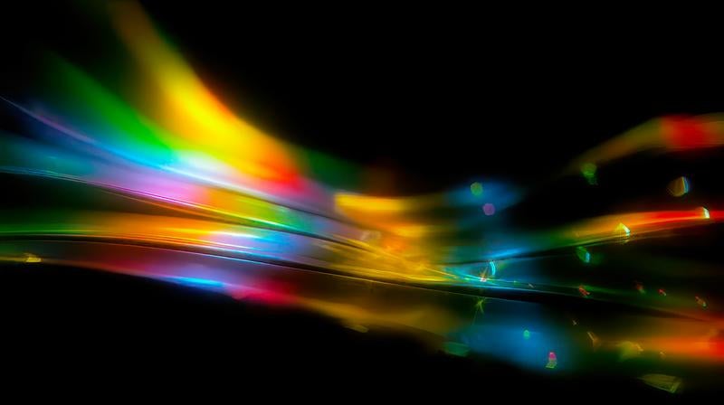 虹色の光が流れる幻想的な抽象アートの写真