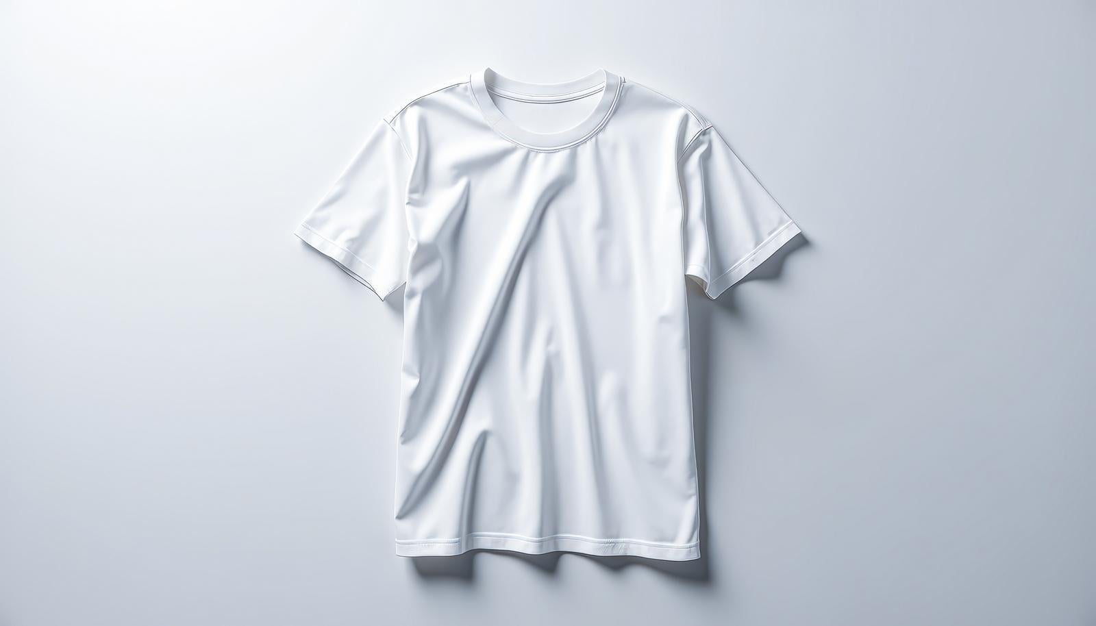 グレーの背景に平置きされた白い無地の半袖Tシャツ