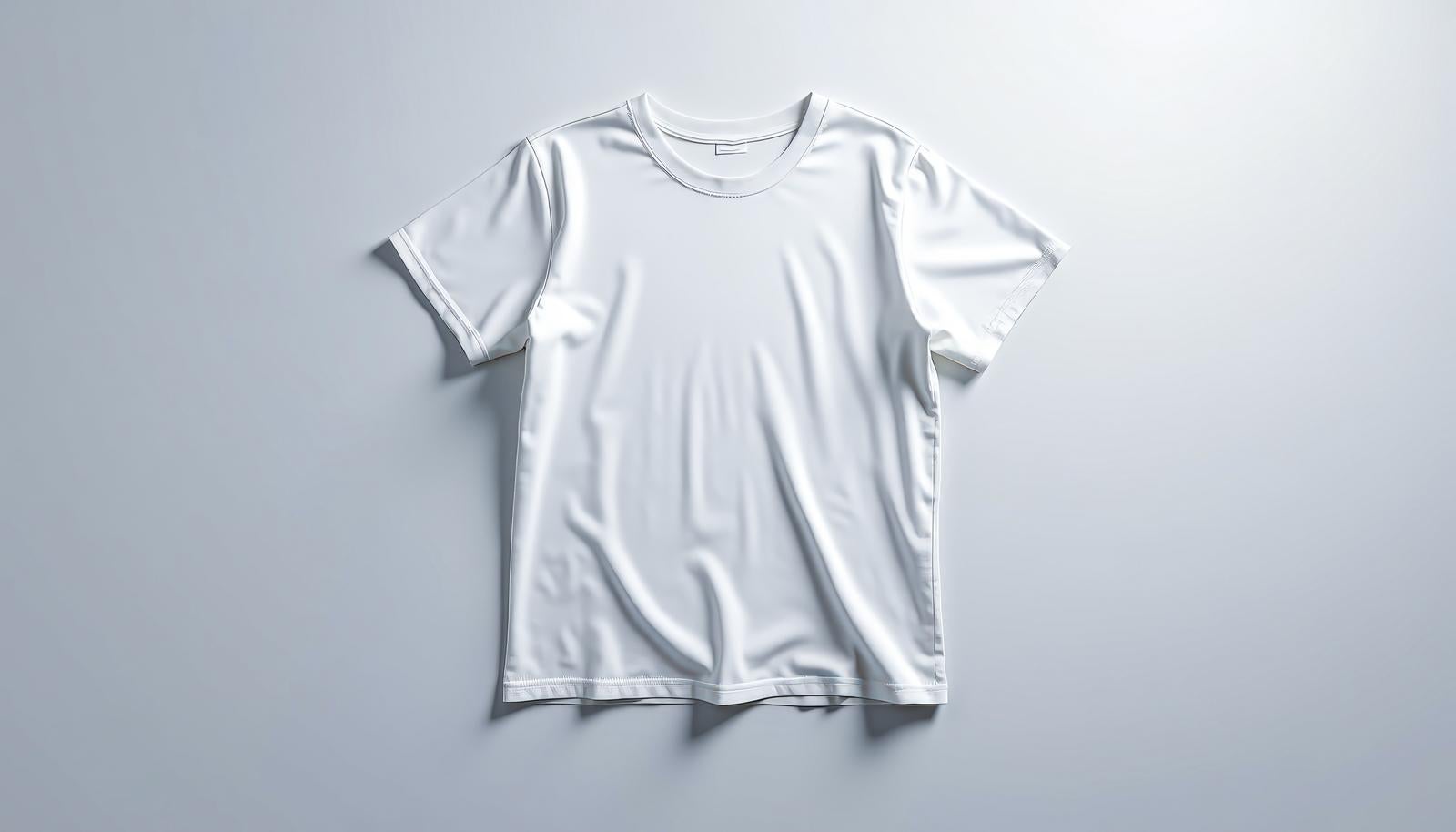 グレーの背景に平置きされた白い無地の半袖Tシャツ