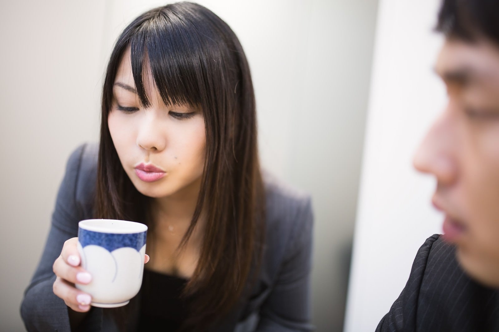 「フーフーしてお茶を冷まし来客の胸を熱くする女性社員」の写真［モデル：大川竜弥 Lala］