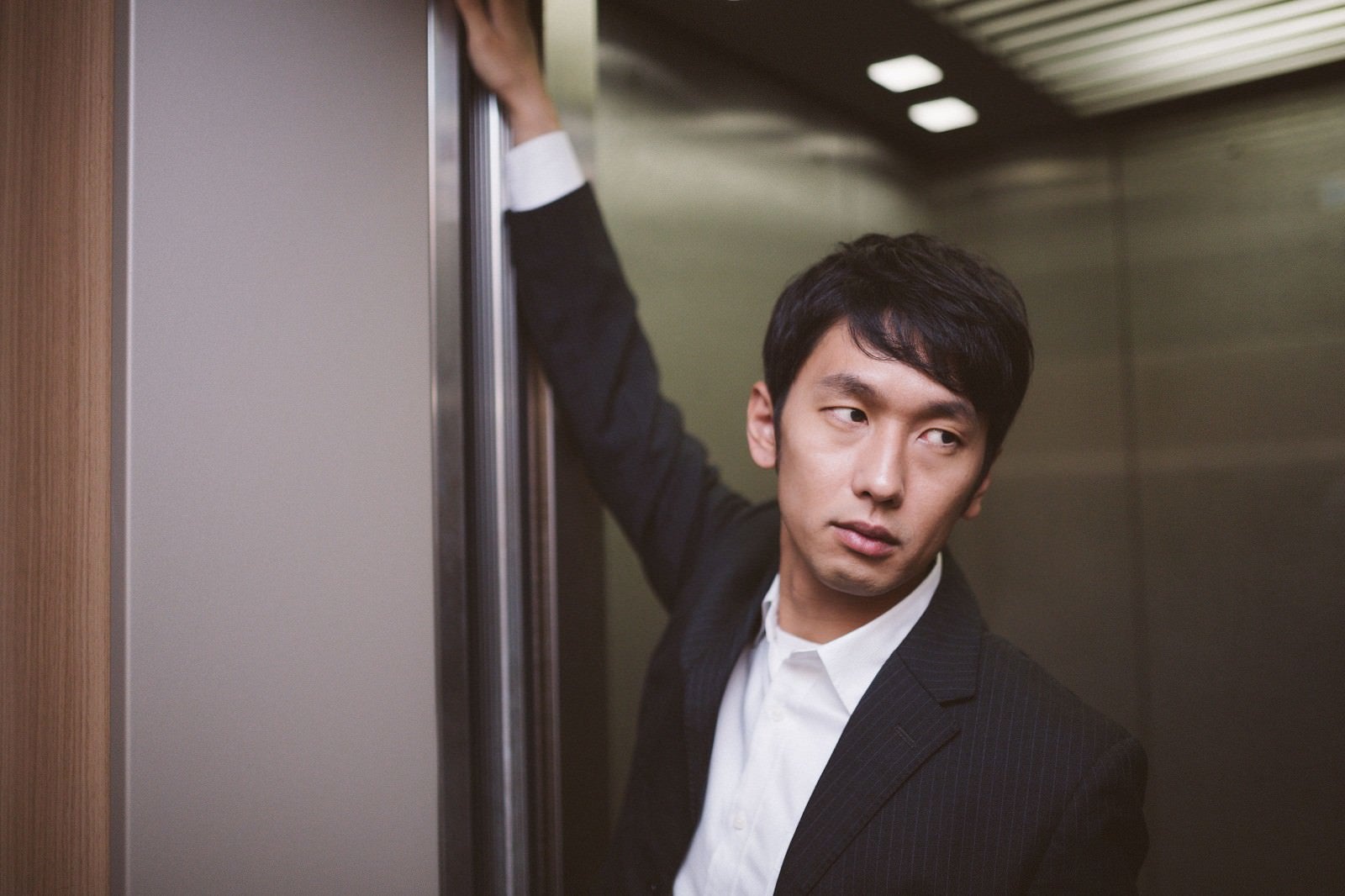 「エレベーターのドアを押さえるデキる営業」の写真［モデル：大川竜弥］