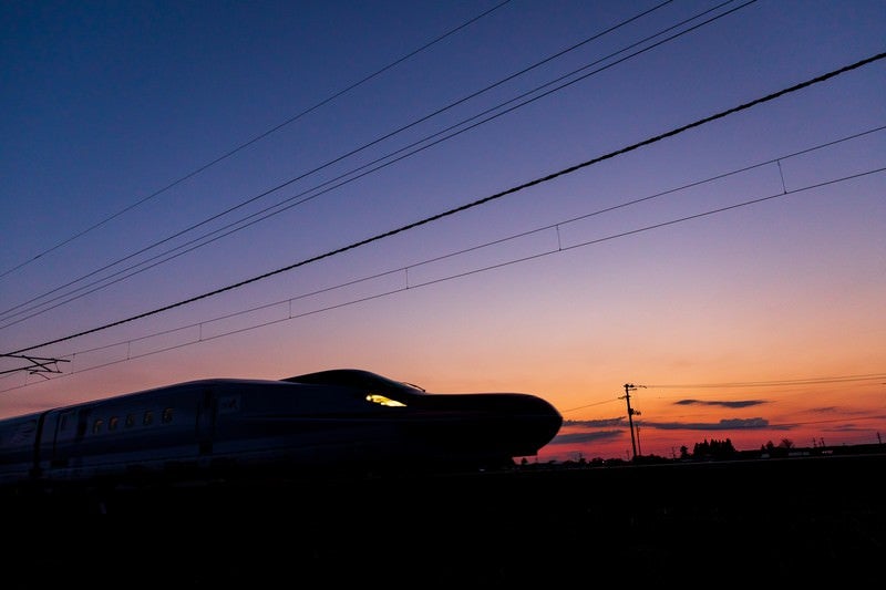 夕焼け空と特別急行列車E6系こまちのシルエットの写真