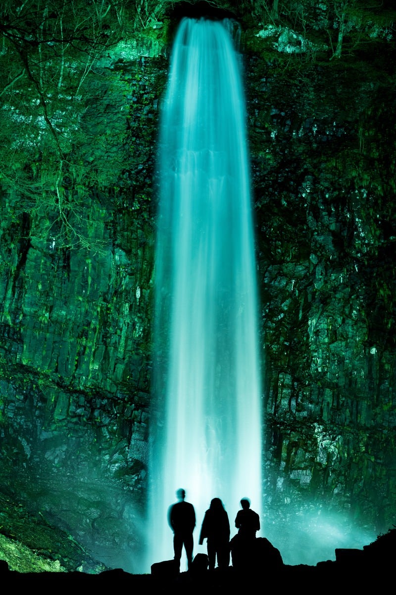 「ライトアップされた玉簾の滝に見入る観光客」の写真