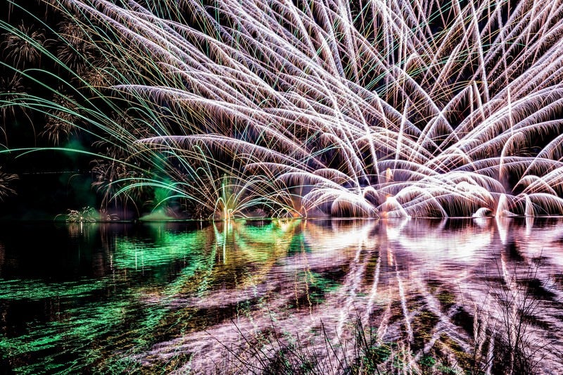 湖面にリフレクションする水上花火（錦秋湖湖水まつり）の写真