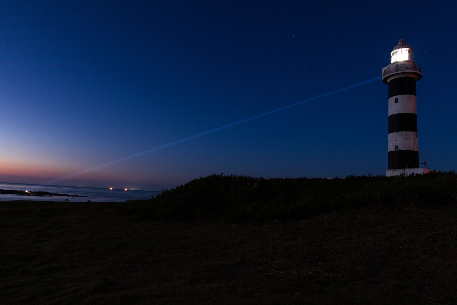 「夜の入道崎灯台から放たれるレーザービーム」の写真