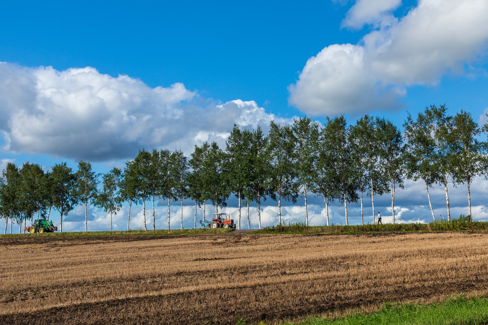 「耕された畑とトラクター」の写真