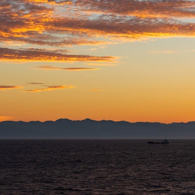 夜明け前の日本海と船の写真