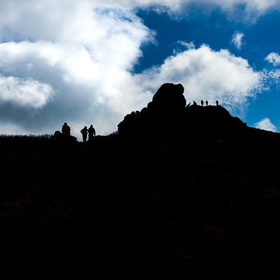 山頂に並ぶ登山者達のシルエットと沸き立つ雲（三ツ石山）の写真