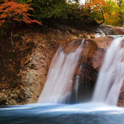 紅葉と赤滝から落ちる水の流れ（秋田県雄勝郡東成瀬村）の写真