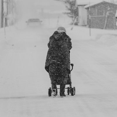 雪が降る中、移動する豪雪地帯に住む高齢者の写真