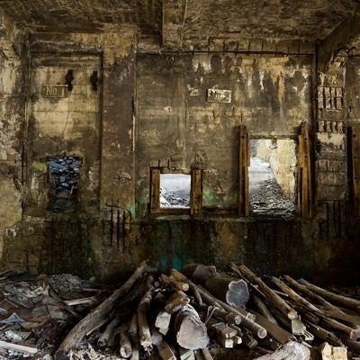 木材が置かれた廃墟の写真