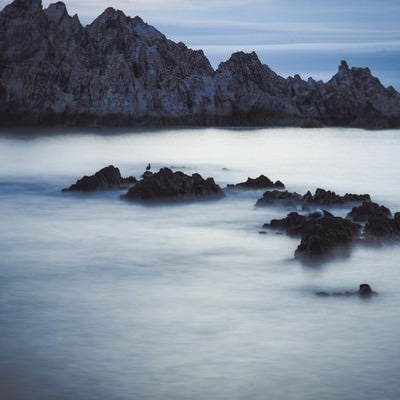 岸壁と霧のように静かな海の写真