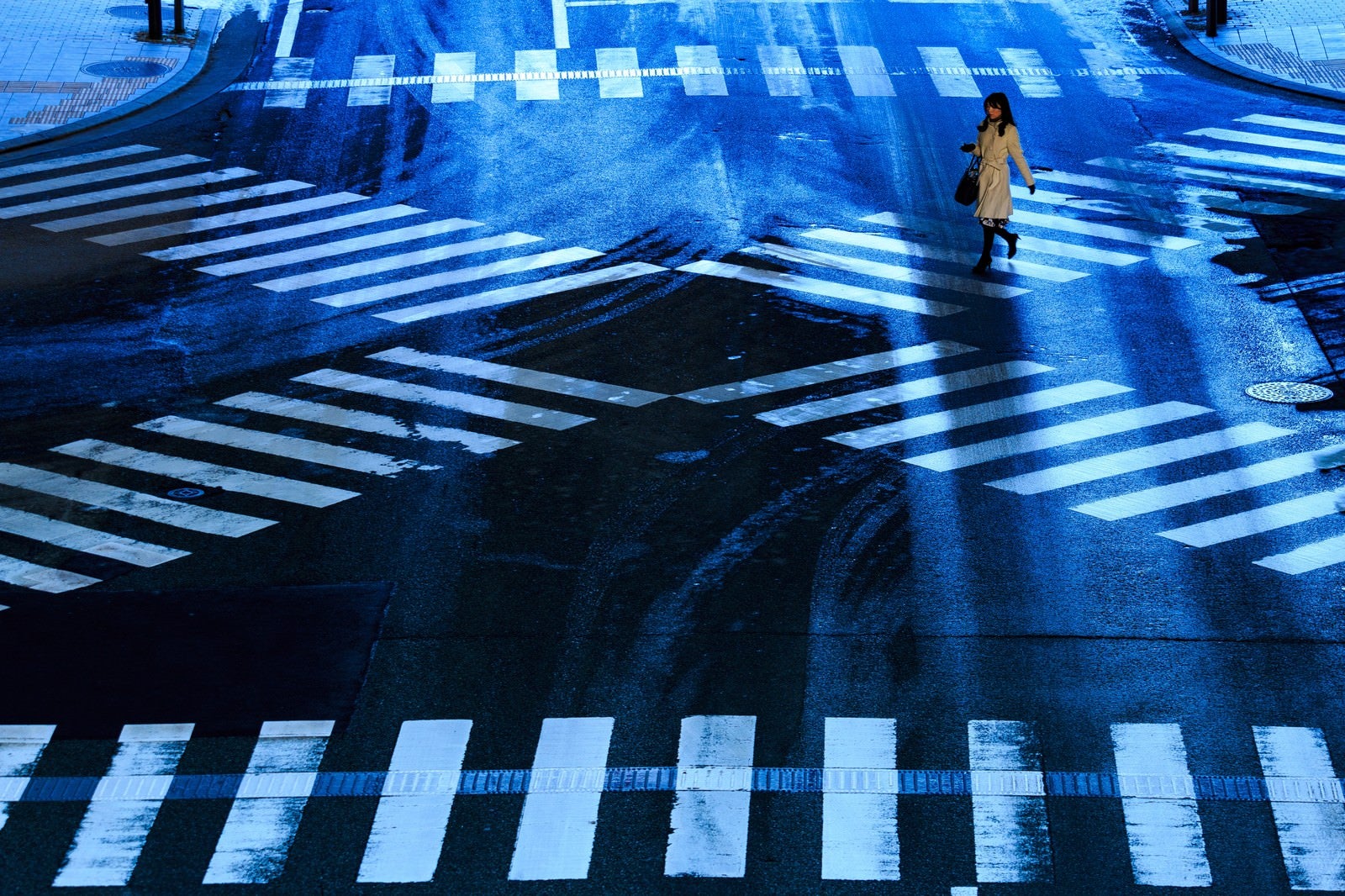 「凍結した交差点と横断する女性」の写真