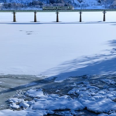 凍った湖を渡る列車（北上線）の写真