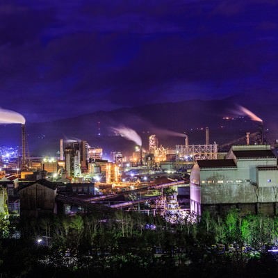 煙たなびく工場夜景の写真