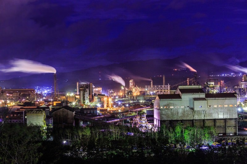 煙たなびく工場夜景の写真