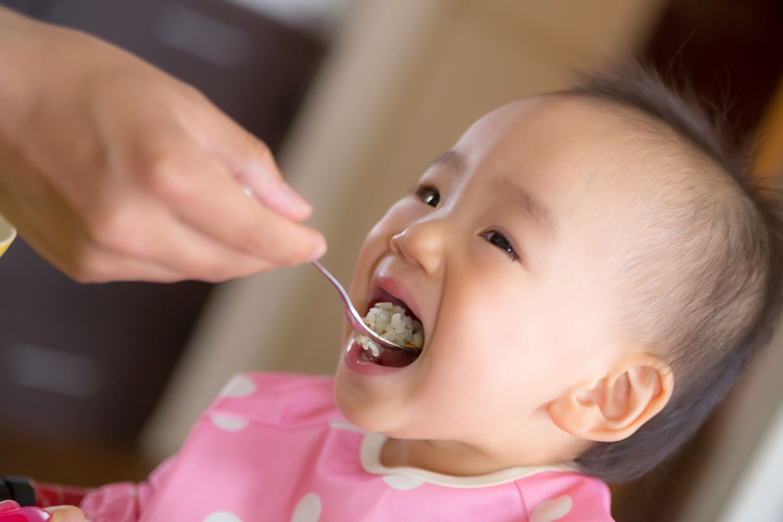 「大きなお口でご飯をあーんする赤ちゃん」の写真［モデル：あんじゅ］