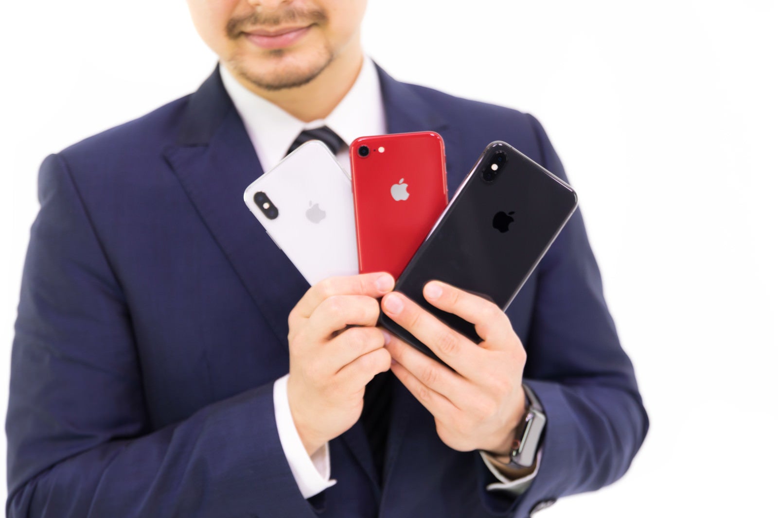 「歴代iPhone三機種を見せびらかすビジネスマン」の写真［モデル：Max_Ezaki］