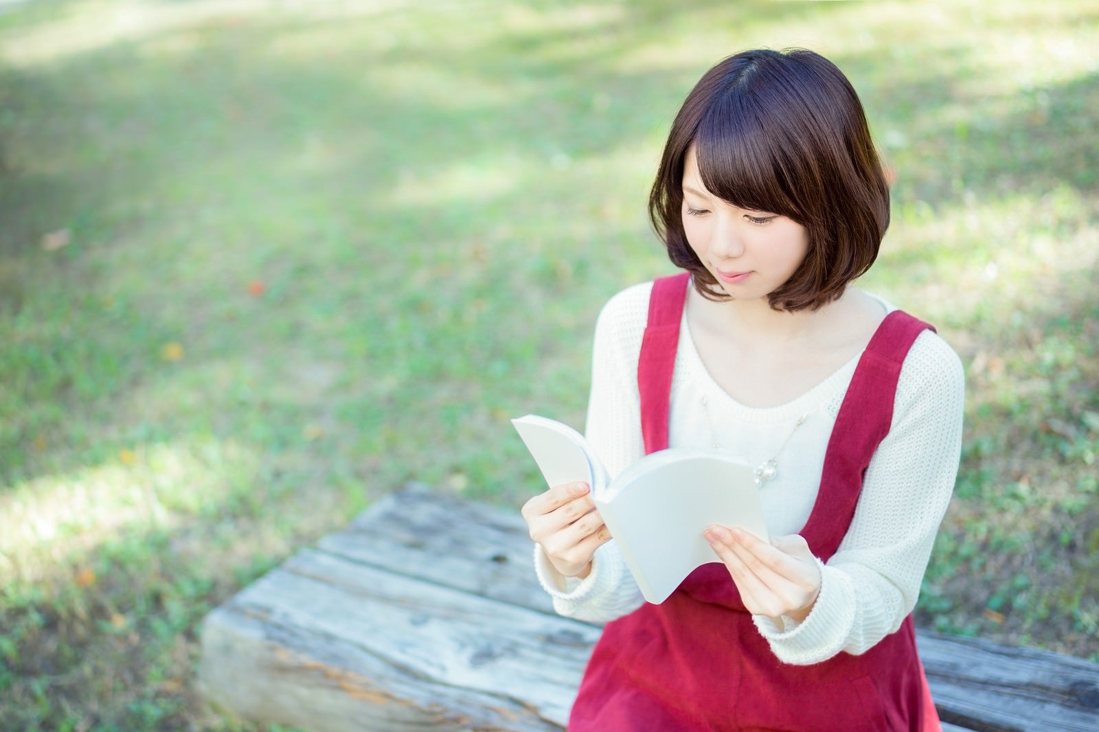 「公園のベンチで読書する美女」の写真［モデル：みき。］