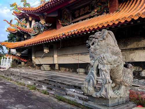 地震で崩れた寺院に鎮座する狛犬の石像（台湾）の写真