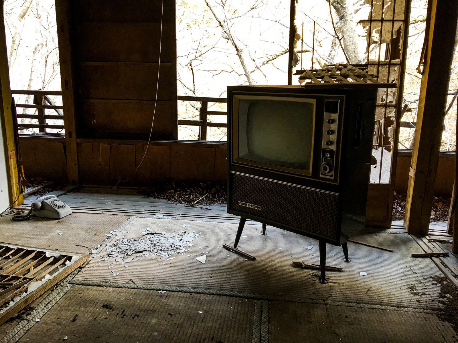 「廃屋に残された古いアナログテレビ」の写真