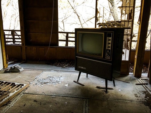 廃屋に残された古いアナログテレビの写真