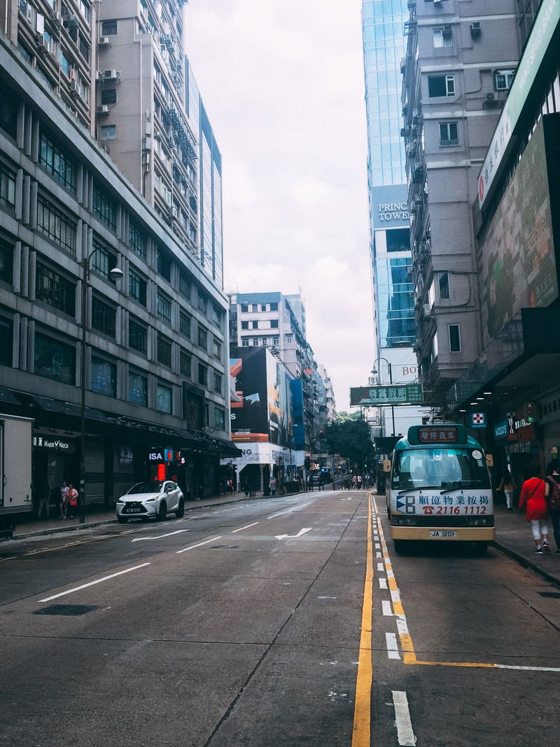 「ビルが立ち並ぶ香港の車道」の写真