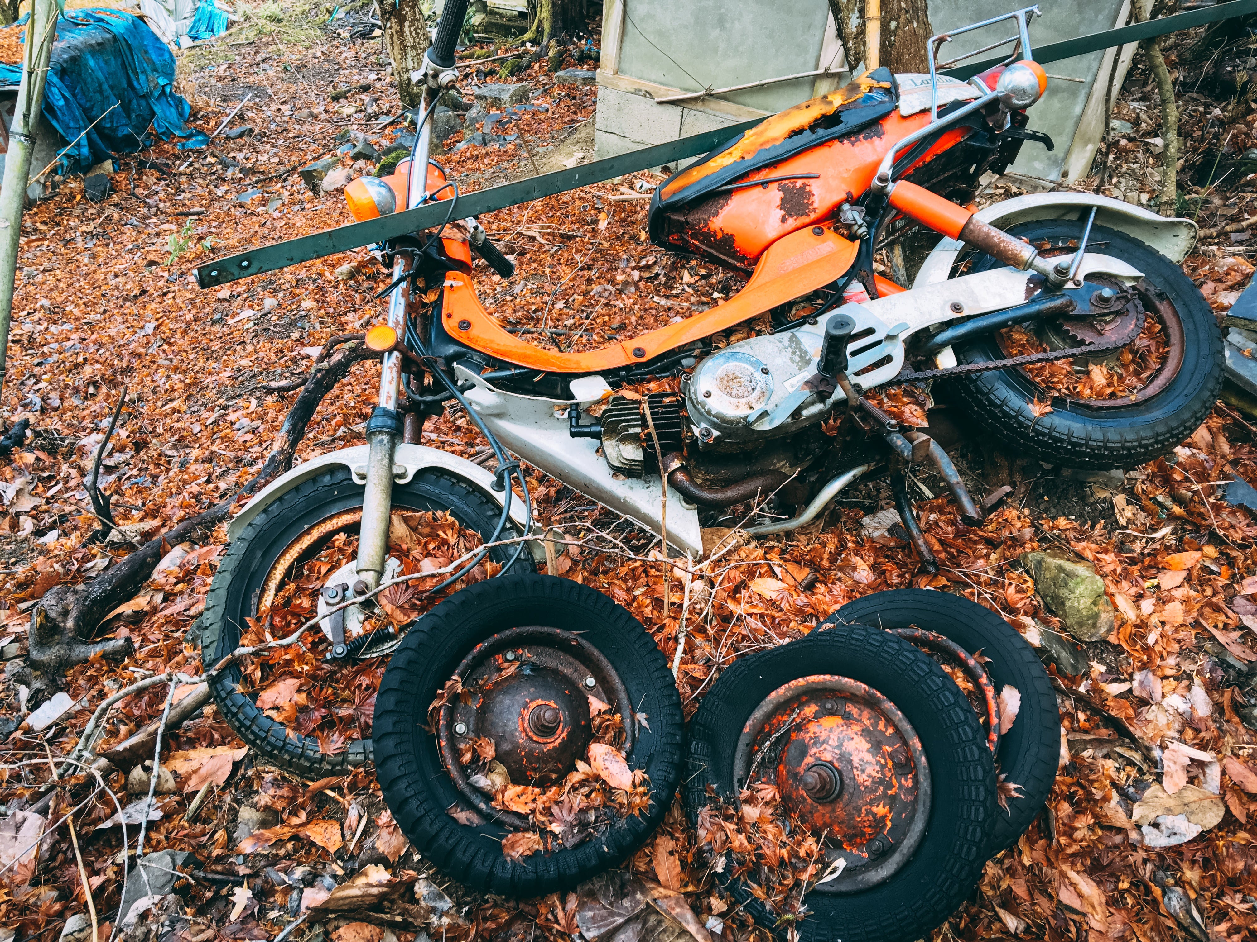 不法投棄されたバイクと複数のタイヤの無料の写真素材 - ID