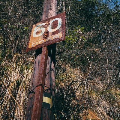 60と書かれた錆びついた鉄看板（JR福知山線廃線敷）の写真