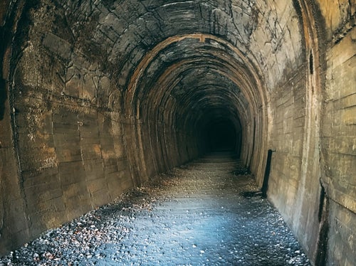 先が見えない古トンネルの内部（JR福知山線廃線敷）の写真