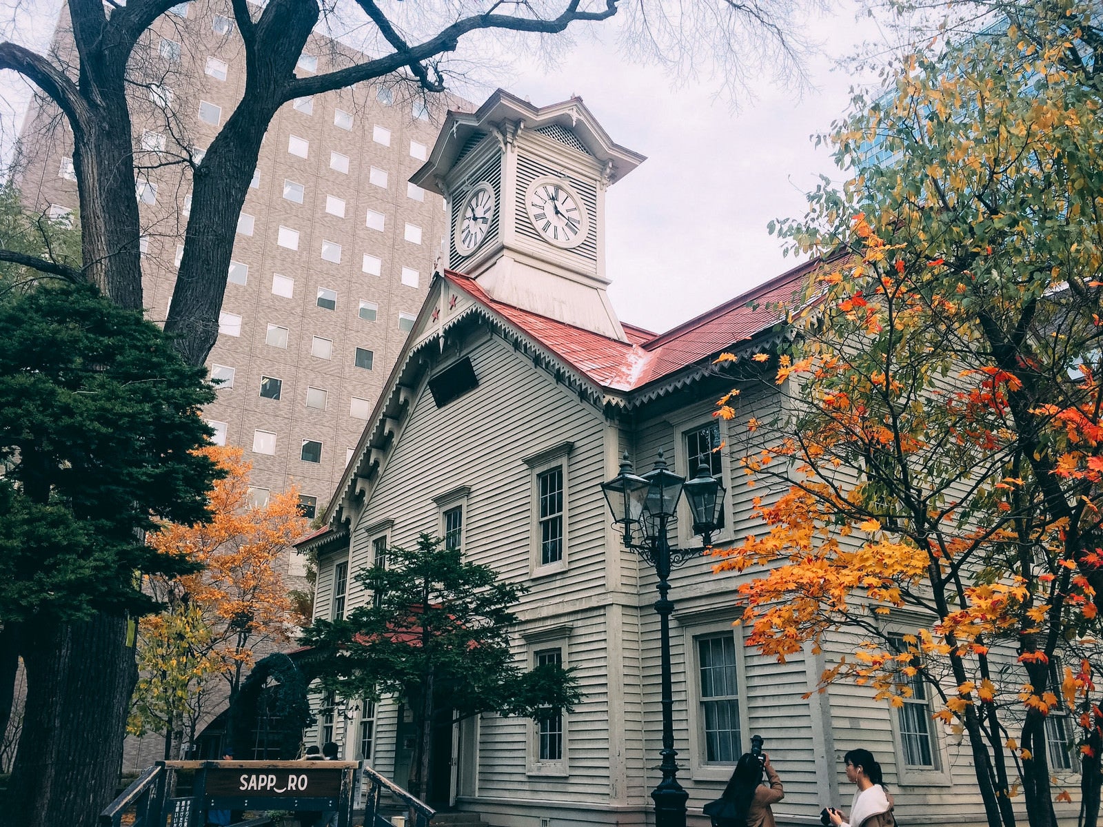 「紅葉に挟まれた札幌市時計台（旧札幌農学校演舞場）」の写真