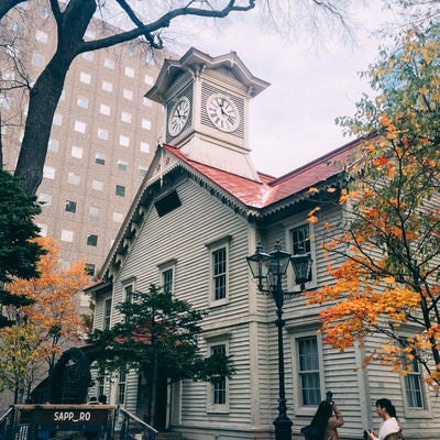 紅葉に挟まれた札幌市時計台（旧札幌農学校演舞場）の写真