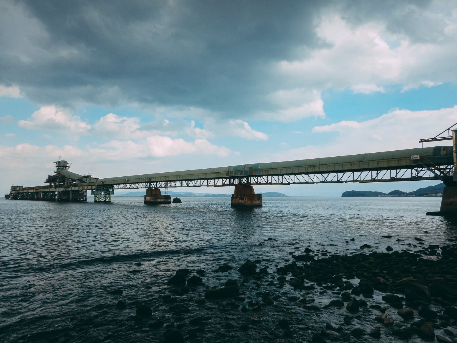 「海の橋にかけた工場と雲」の写真