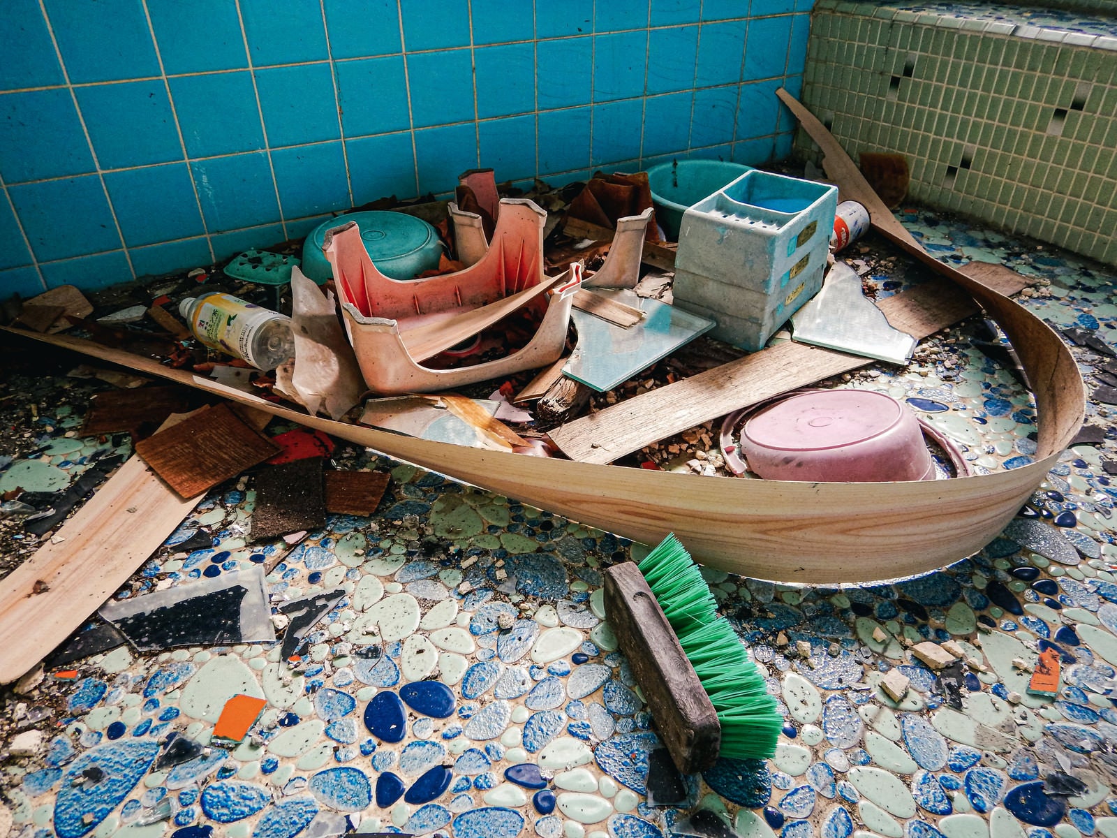 「藍色タイルを敷き詰められた倒壊した古民家の風呂」の写真