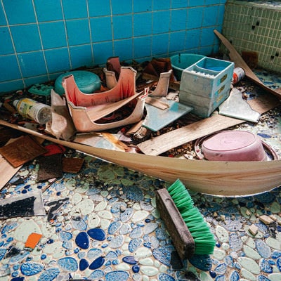 藍色タイルを敷き詰められた倒壊した古民家の風呂の写真